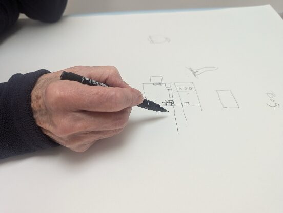 A hand drawing a floor plan of a house